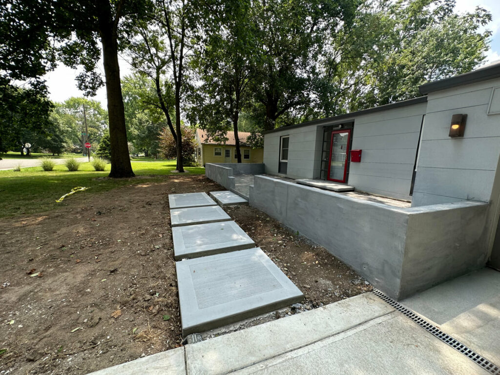 modern concrete pathway to the front door of the house